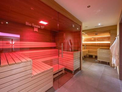 Modern sauna area with wooden benches and soft lighting in a wellness space.