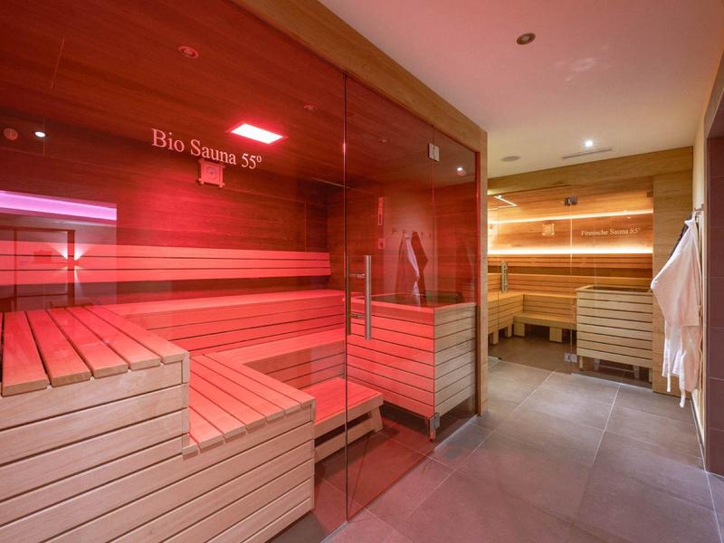 Modern sauna area with wooden benches and soft lighting in a wellness space.