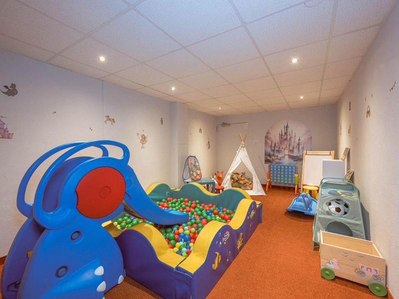 Colorful children's playroom with ball pit, play tent, and toys, cozy and safe.