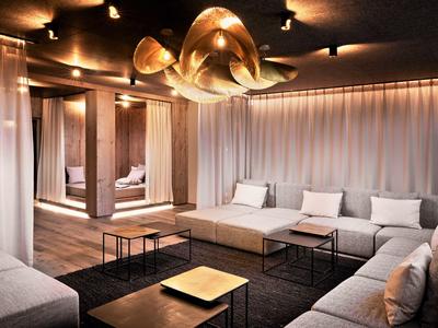 Modern living room with gray sofas, wooden columns, and decorative ceiling light.