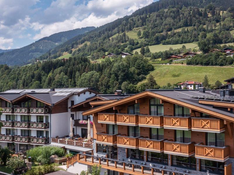 Budynki hotelowe z balkonami na tle zalesionego krajobrazu górskiego i niebieskiego nieba