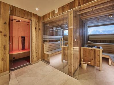 Espace bien-être moderne avec sauna en bois et salle de détente au décor chaleureux en bois.