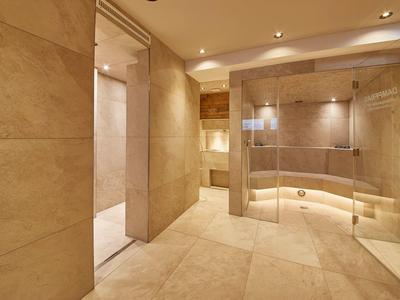 Salle de bain moderne avec grandes dalles beiges et douche en verre