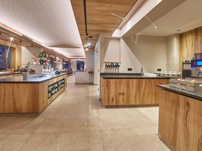 A modern buffet with wood paneling and warm lighting in a hotel restaurant.
