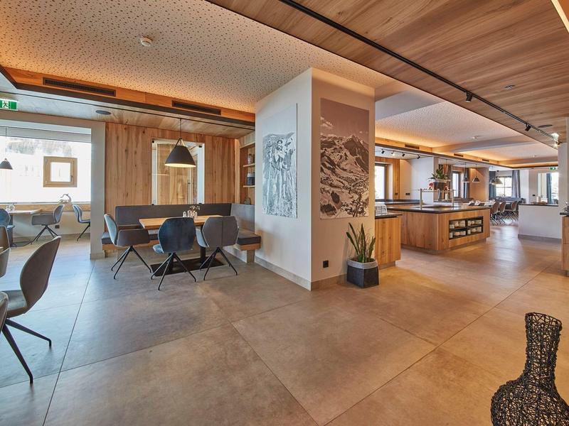 Espace de restaurant d'hôtel moderne avec accents en bois, sièges et disposition spacieuse.