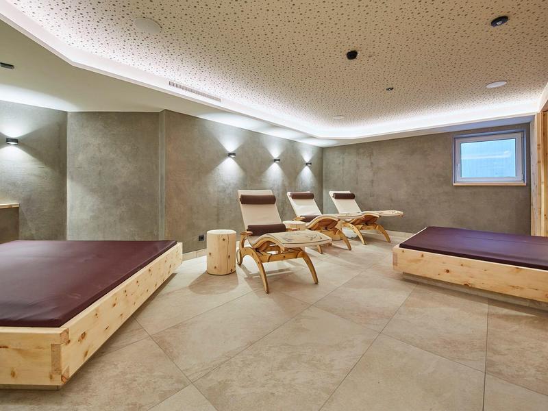 Salle de bien-être moderne avec chaises longues et éclairage tamisé.