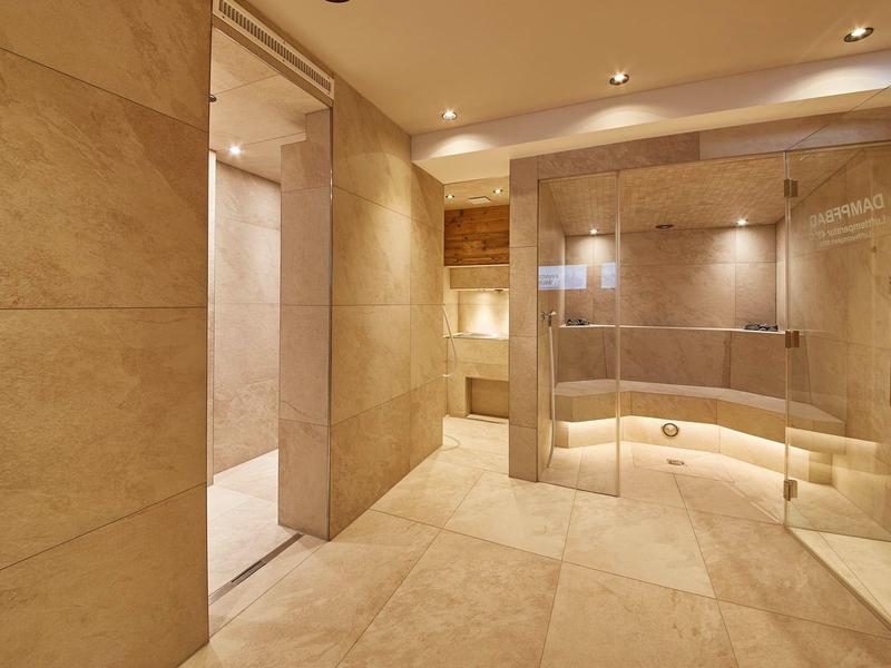 Salle de bain moderne avec grandes dalles beiges et douche en verre