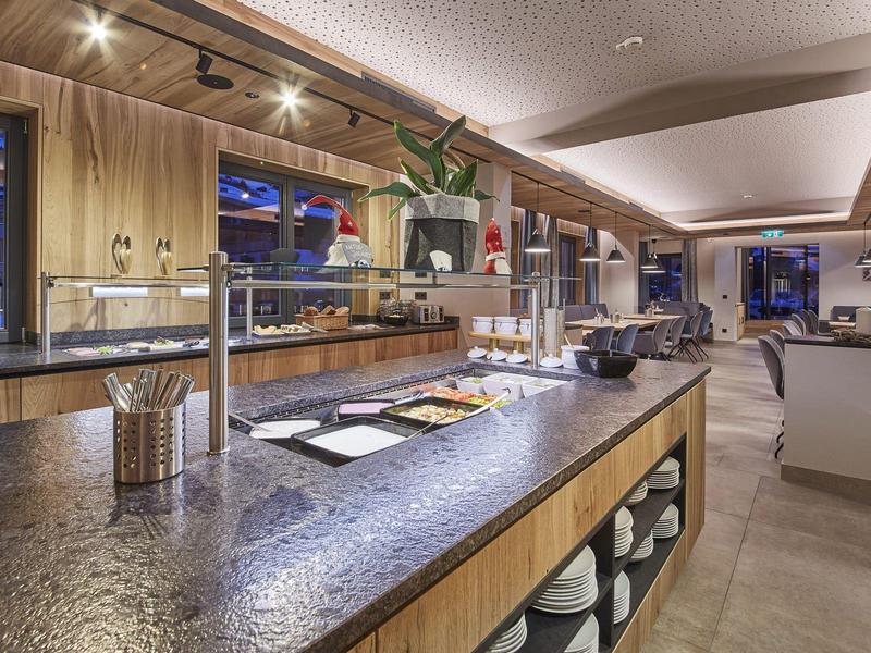 Espace buffet moderne avec comptoir éclairé et panneaux en bois dans un hôtel.