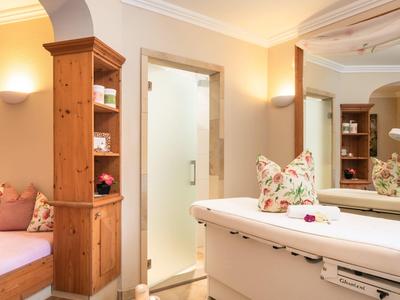 Jasny pokój hotelowy z prysznicem, drewnianą półką, sofą i nowoczesną łazienką