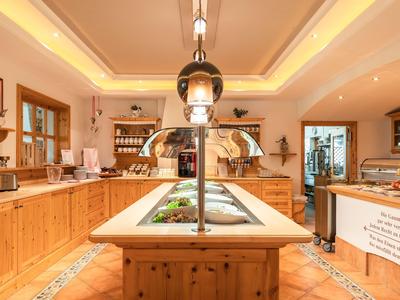 Bufetová oblast v teple osvětlené restauraci s dřevěným nábytkem a salátovým barem.