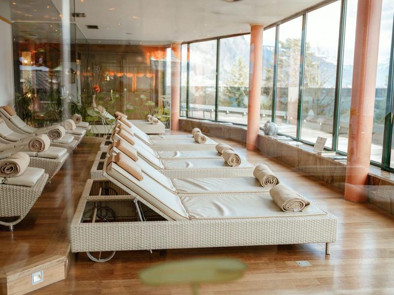 Světý, moderní salonek s bílými lehátky a velkými okny s výhledem.