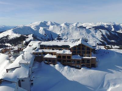 Un hotel situato in un paesaggio montano innevato con vista su cime innevate.
