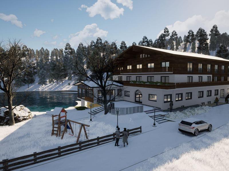 Chalet nevado en las montañas con vista a un lago congelado y árboles cubiertos de nieve
