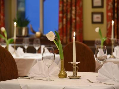 Elegancki stół z świecą i kwiatem w ciepło oświetlonej restauracji.