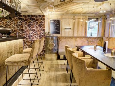 Elegant hotelrestaurant met barkrukken, comfortabele stoelen en warme lichtsfeer.