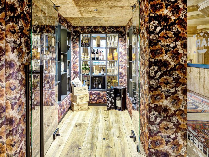 Gang met uniek patroon op de muren, houten vloer en moderne glazen deuren.