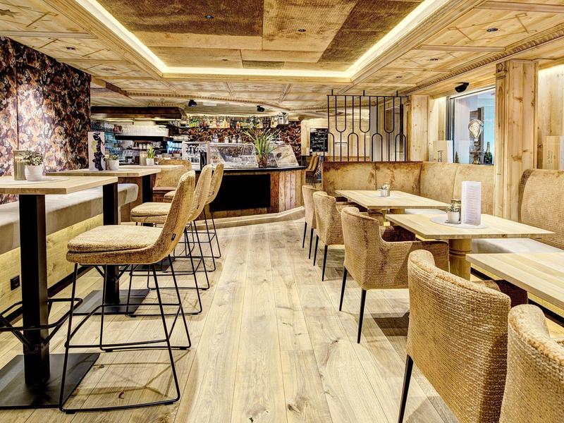 Moderne eetruimte met houten vloer en comfortabele stoelen in een restaurant.