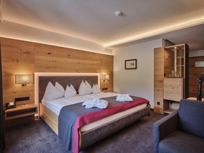 Modern hotelkamer met tweepersoonsbed, sfeerverlichting en open badkamer.