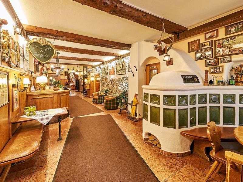 Coin salon d'hôtel chaleureux avec poutres en bois et chauffage au poêle rustique.