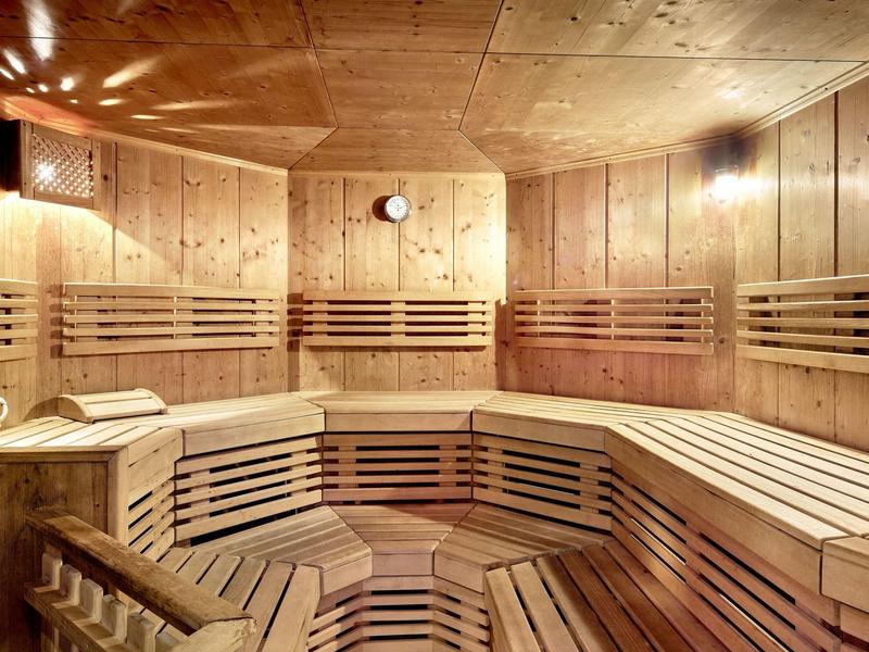 Wnętrze sauny z drewnianymi ławkami i ciepłym oświetleniem