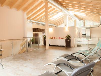 Bright wellness area with lounge chairs and skylights under a wooden beam ceiling.
