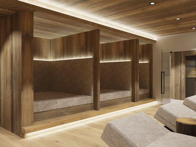 Interiér moderního spa s dřevěnými zdmi, třemi vestavěnými lehátky a pohodlnými křesly.
