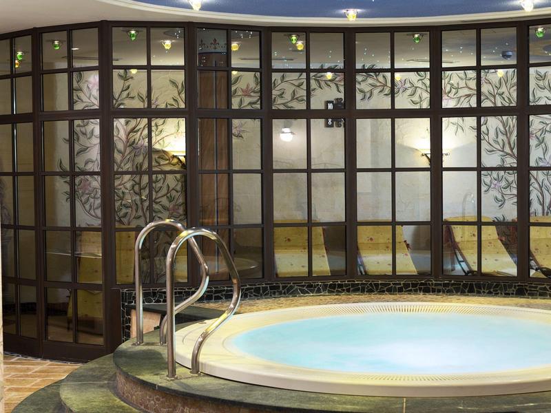Espace spa moderne avec jacuzzi et plafond étoilé dans un hôtel.