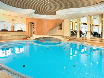 Moderní vnitřní bazén s jasně modrou vodou a elegantním designem.