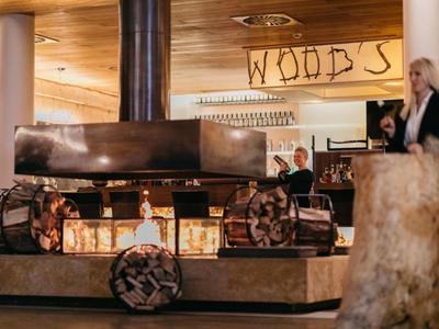 Intérieur chaleureux avec cheminée et décoration en bois dans un restaurant d'hôtel nommé WOODS.