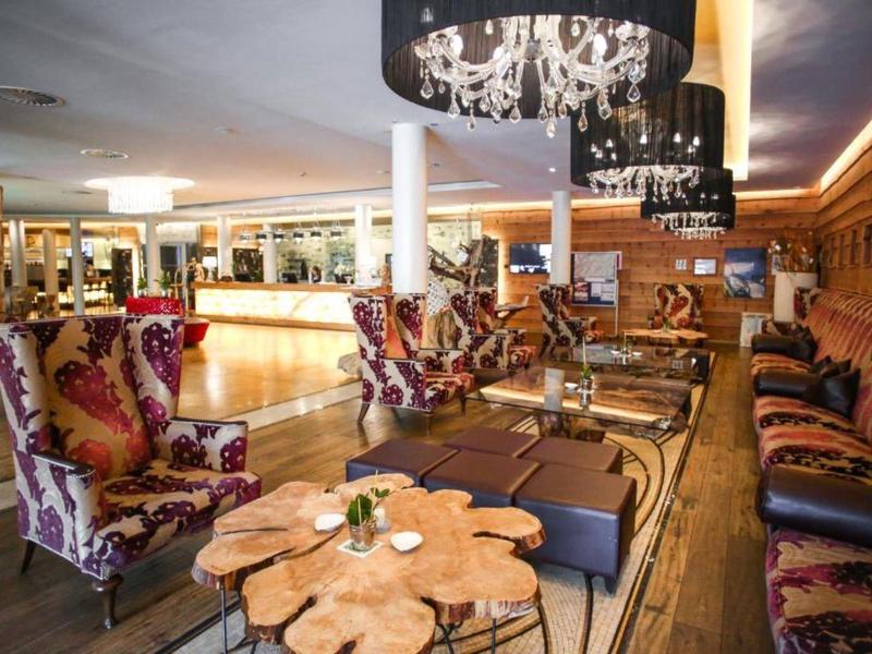 Elegantní hotelový lounge s dřevěnými stoly a vzorovanými křesly