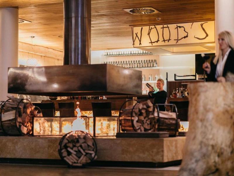 Pohodlná hotelová lounge s rustikálním krbem a dřevěnými prvky.