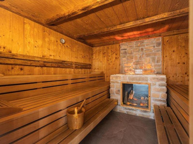 Houten sauna met open haard en banken voor ontspanning.