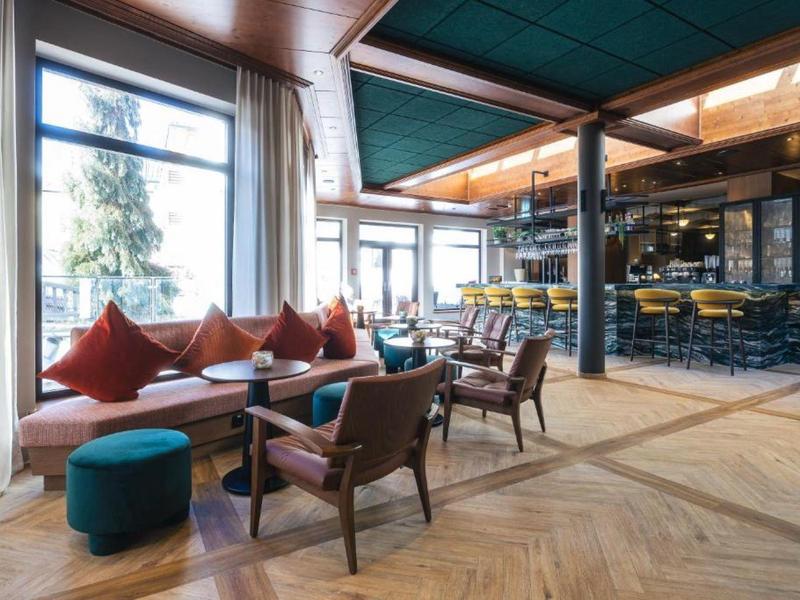 Gezellig loungegedeelte met zitplaatsen en grote ramen in een hotel.