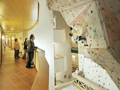 Innenaufnahme einer Kletterwand mit Zuschauern auf der Galerie