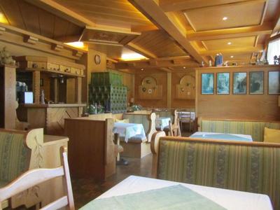 Restaurant rustique avec meubles en bois et tables dressées sous un éclairage chaud.