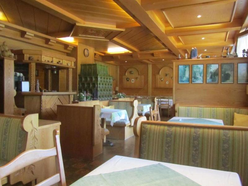 Przytulna jadalnia hotelowa z klasycznymi drewnianymi meblami i nakrytymi stołami.