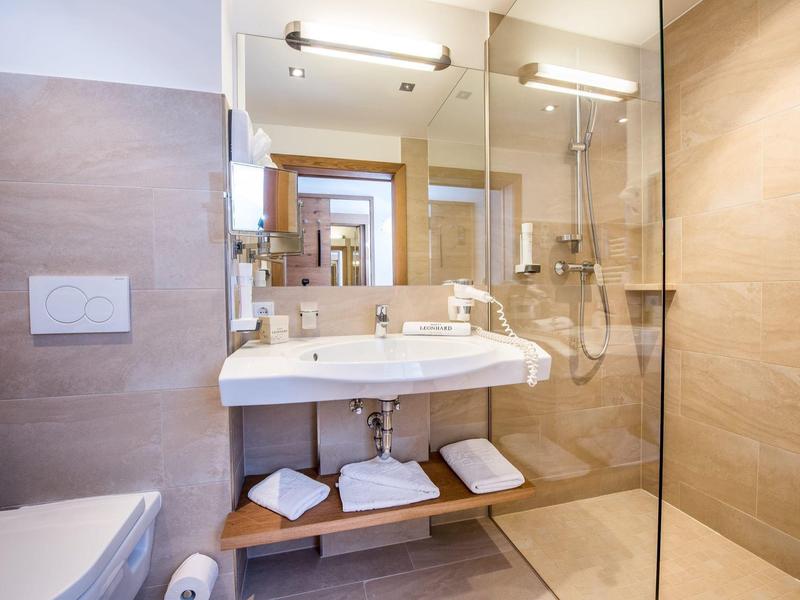 Modernes Badezimmer mit großem Spiegel, Waschtisch und begehbarer Dusche