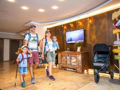 Familia con dos niños y equipaje caminando por el vestíbulo del hotel.