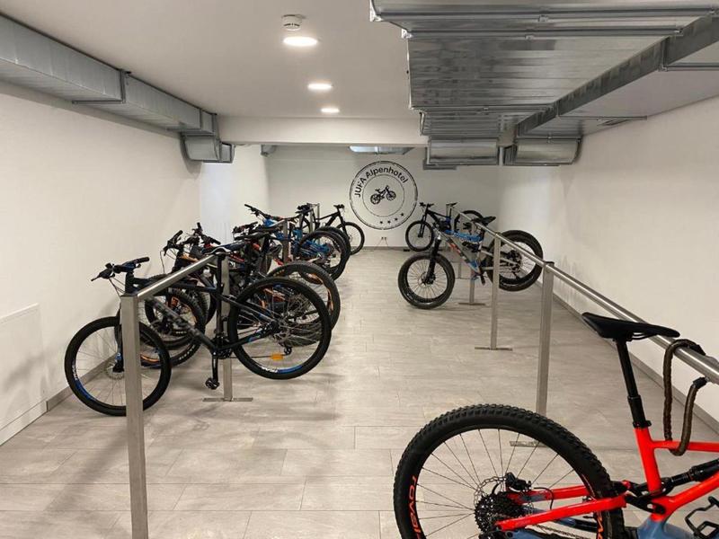 Bicicletas en una sala alargada y luminosa con paredes blancas y luces en el techo.