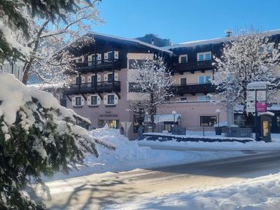 Un bâtiment d'hôtel enneigé avec des arbres couverts de neige par une journée d'hiver ensoleillée.