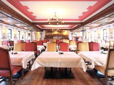 Un elegante ristorante con tavoli apparecchiati e sedie in luce calda.