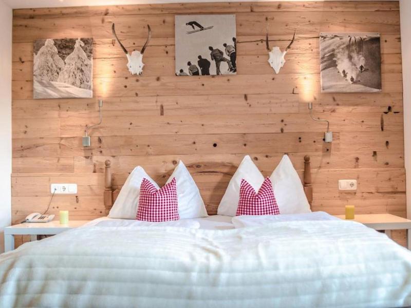 Chambre d'hôtel confortable avec mur en bois, tableaux décoratifs et oreillers doux.