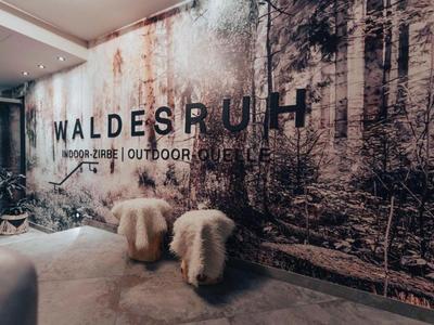 Stěna s lesním motivem a nápisem 'WaldesRUH' se dvěma chlupatými stoličkami před ní.