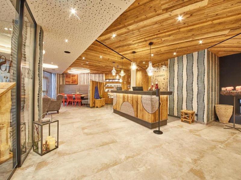 Moderní hotelová recepce se dřevěným stropem a útulnou atmosférou.