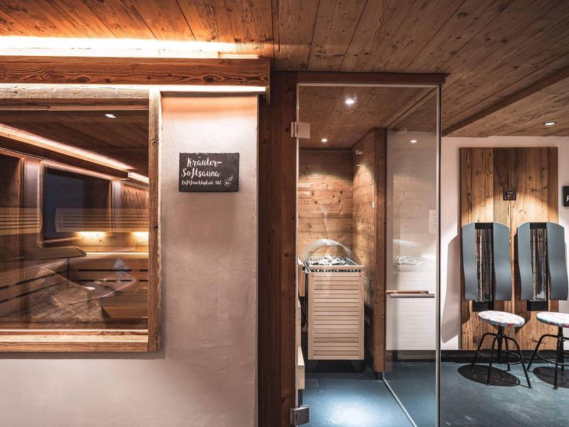 Moderner Wellnessbereich mit Sauna und entspannenden Sitzplätzen in warmem Licht.
