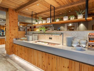 Moderne hotelkeuken met houten lambrisering en stijlvolle planken met planten.