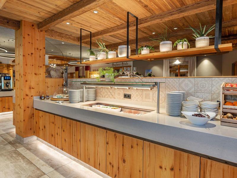 Moderne hotelkeuken met houten lambrisering en stijlvolle planken met planten.