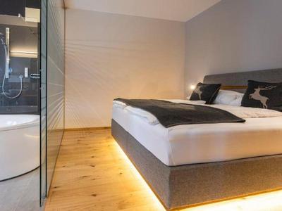 Habitación de hotel moderna con cama doble y iluminación indirecta debajo de la cama.