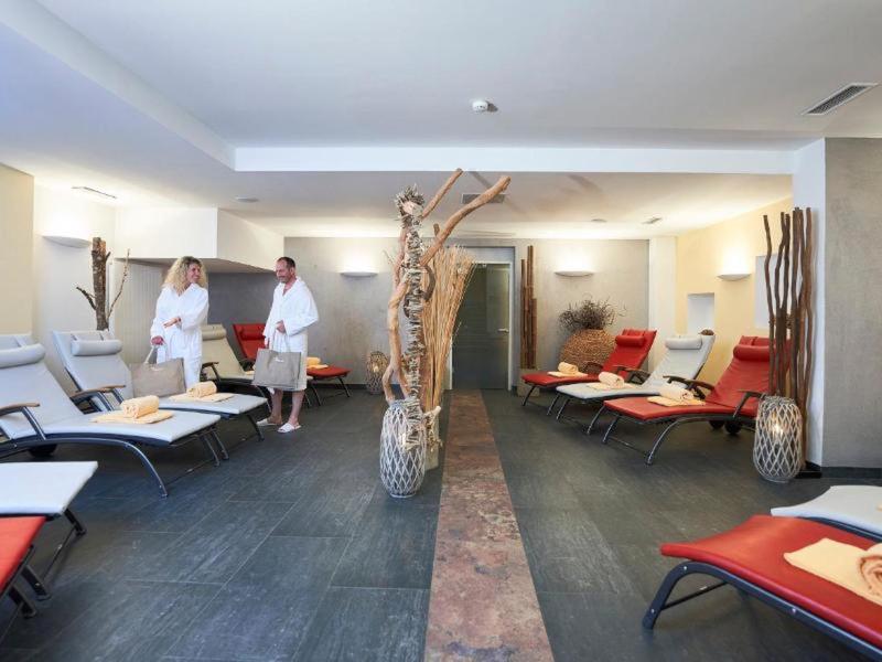 Sala de relajación moderna con tumbonas, velas y ambiente tranquilo.