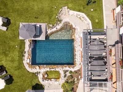 Veduta aerea di una piscina rettangolare con lettini e prato intorno